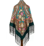 Colorful patterned teal green shawl with fringes and vintage pink rose flowers on a white background