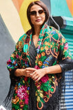 Woman wearing a colorful floral oversized shawl with a vintage bright peony flowers and green leaves in Slavic traditional style.