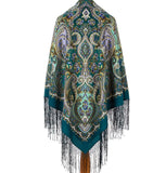 Decorative sea blue and green shawl with intricate paisley pattern and fringes on a white background with pale yellow and green pattern.