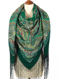 Green paisley Slavic scarf with fringes on a mannequin. A woman wearing this green shawl with yellow ornament stands out with its rich color contrast and timeless look. 