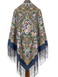 Decorative woolen shawl with floral patterns and blue long fringes on a white background