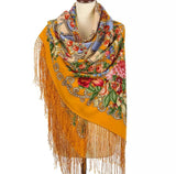 Colorful Slavic vintage floral-patterned scarf with large peony flowers and silky fringe with bright orange base on a mannequin against a white background