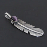A silver feather-shaped pendant with a purple tiger eye gemstone on the top center, displayed against a black background.