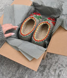 Pair of woolen slippers with decorative patterns in a box