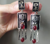 Elevate your style with our 925 silver jewelry from Armenia. These boho style, 7 cm long dangle earrings feature a stunning red oval garnet. With no irritations, they're perfect for the pomegranate-loving Persephone in your life. Shop now for high quality and unique pieces.
Upgrade your jewelry game with our high quality 925 silver earrings from Armenia. These boho style dangle earrings feature a striking red oval garnet that catches the eye. Embrace the elegant combination of black, silver, and red.