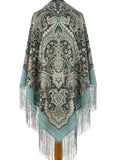 Decorative  green shawl with intricate patterns and fringes on a white background. This ethnic green scarf with paisley ornaments in teal and black is graceful and easy to wear. The traditional design and large size make it both stylish and practical.