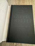 Black book Harry Potter rare edition with embossed text on a wooden surface