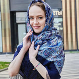 Woman wearing a blue patterned headscarf outdoors