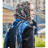 Woman wearing a colorful headscarf with floral patterns in an urban setting