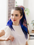 A woman wears this warm blue and red woolen shawl with fringe on her hair as a Slavic decor. Soft, non-prickly, and elegant, it is ideal for stylish everyday use.