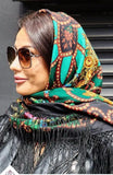 Woman wearing a green headscarf with vintage yellow flowers and silky fringe.