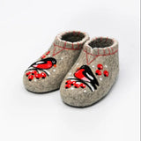 A pair of handmade natural sheep felt house booties in a heathered gray-beige color, decorated with embroidered red birds and red berries, shown on a plain white background.