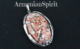 This large oval handmade pendant is made of silver and leopard paw jasper. The pattern resembles animal print. The color is white gray and red. This stone is also called poppy jasper.