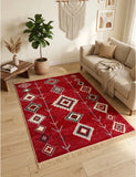 A red area rug with Armenian geometric taraz pattern and fringe, styled in a bright, modern living room next to a beige sofa and a potted plant.