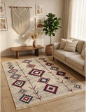 A rectangular area rug with a bohemian geometric pattern in beige, red, blue, and black, styled in a warm, modern Armenian living room next to a beige sofa and a potted plant.