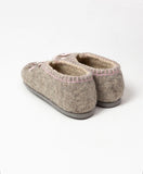 Natural merino wool slippers with rubber outsole from back on a white surface