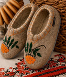 Woolen slippers with rowanberry embroidery on Slavic table runner and round cookies.