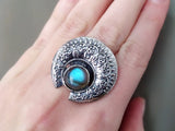 Armenian Silver ring with a blue labradorite round gemstone on a hand against a neutral background