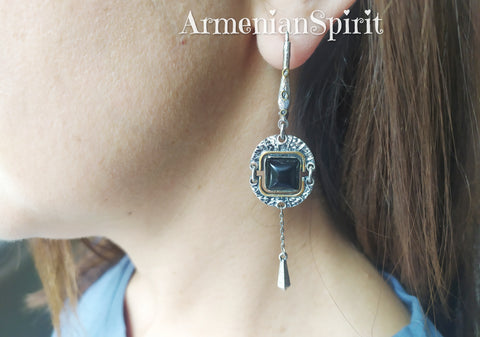 These earrings looks like from another planet. The design is inspired of space and other planets design. The earrings is very long with square black gemstone and gilded details.