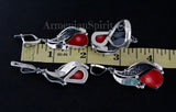 Jewelry set with red heart stones and silver designs on a black background, measured against a ruler.