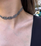 Silver Armenian traditional filigree necklace worn by a person with a blurred background