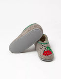 A pair of gray felt house slippers with a red berry and green leaf embroidery on the side, shown on a clean white background.
