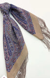 Paisley patterned beige and blue scarf with fringes on a white background