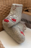 Gray indoor booties made of merino natural wool with red berry design on a white surface