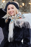 A smiling woman models a premium merino wool palantine in a traditional Slavic style. The ivory shawl is wrapped snugly around her neck, showing off a sophisticated mix of fine floral borders and a bright white background filled with colorful, blooming rose motifs that give a very warm and classy winter look.