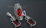 Pair of red gemstone earrings and ring with silver detailing and marcasite on a dark background. The jewelry set looks rich and luxury, perfect for rich party or wedding.