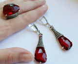 Indulge in luxury with our handmade Armenian jewelry. Crafted with high quality sterling silver, this set features a large ring and long dangle earrings adorned with dazzling ruby red and marcasite gemstones in a vintage 19th century style. The perfect gift for the sophisticated woman.
