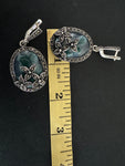 These one of a kind, feminine and classic silver earrings feature a 2 inch oval dangle design with stunning flower marcasite and oval moss agate green gemstones. Perfect for grandmas, these unique earrings are a must-have addition to any jewelry collection.
