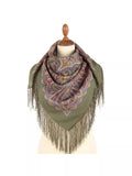 Green scarf with paisley pattern and fringes on a mannequin against a white background