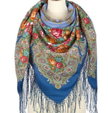Colorful paisley scarf with floral patterns and fringes on a mannequin against a white background
