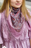 Woman wearing a purple dress and patterned scarf in Slavic style with fringes