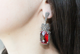 Armenian Spirit long Tudor earrings with red stone and marcasites in 925 silver on a woman earlobe.