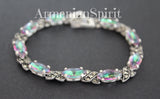 This bracelet is a captivating blend of vintage charm and modern shimmer, making it a truly eye-catching piece. The combination of the intricate, almost antique-looking marcasite with the vibrant, almost otherworldly rainbow green stone creates a striking juxtaposition that's hard to ignore. The green stone is the star of the show. Depending on the light, it seems to shift in color, revealing hints of blues, greens, and even hints of gold. It's truly mesmerizing and adds a touch of magic to the design.

