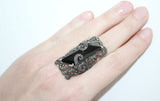 A ring on women`s hand. Black rectangle gemstone, marcasite and made of sterling silver 925.