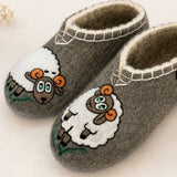 Natural woolen medical slippers with sheep embroidery on a white background