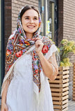 This extra-large white head scarf showcases a classic Slavic herbal motif in warm red and yellow hues. Styled as a generous sheep wool wrap, it reflects vintage folk aesthetics, crafted from natural merino wool with an elegant silky fringe.