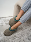 Natural merino wool slippers on women`s legs