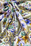 Close-up of floral and paisley patterned shawl with blue, green, and yellow colors.
