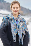 Large shawl on a blond woman with blue peone flowers. 