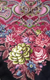 Oversized merino wool palantine in a traditional Slavic style. The shawl showing off a sophisticated mix of deep red paisley borders and a dramatic black background filled with colorful, blooming rose flowers that give a very warm and classy winter look.