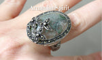 Expertly handcrafted in Armenian design, this sterling silver 925 ring features a large oval moss agate gemstone, accented with marcasite flowers. The big cabochon and vibrant green hue elevate any outfit, making it the perfect statement piece. Enjoy its timeless elegance and superior quality.
