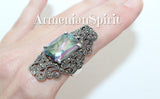 Large ring with green mystic topaz stones and small marcasite accents, displayed against a black background with the brand name 'Armenian Spirit' written at the top.