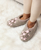 Natural wool medical slippers with pink embroidery on woman`s feet