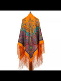 Colorful patterned wrapping shawl with fringes on a white background. The shawl made in orange bright color with red and blue ornaments.