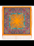 Colorful paisley patterned scarf with orange border and fringes on a white background