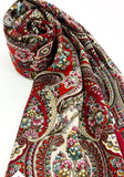 Colorful paisley patterned red large wrapping shawl made of natural merino wool on a white background